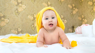 Cute Baby wearing a yellow hooded bath towel, with the ability for custom embroidered name on it.