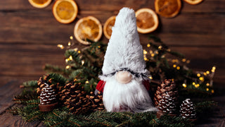 Christmas Gnome sitting with Pine Cones and Christmas decorations