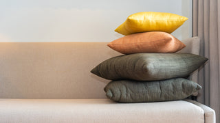 A stack of pillows on a couch, that can be customized with an image or text.