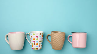 An assortment of coffee mugs with various designs on a blue background.