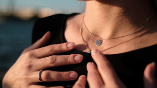 Woman wearing a sterling silver round monogram necklace in the sunset