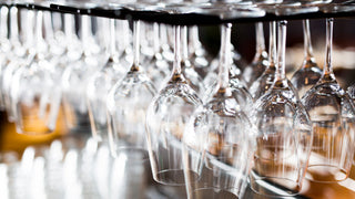 Wine glasses hanging from a bar rack.