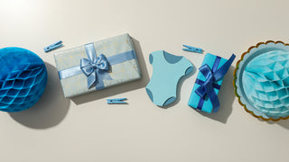 AN assortment of blue baby gifts, including a onesie, and a couple blue wrapped gifts.