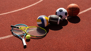 image of track with various pieces of sporting equipment, including tennis rackets, balls, volleyball, football, soccer ball, basketball