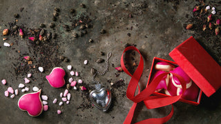 Various Valentine's gifts on a marble background, including a heart necklace