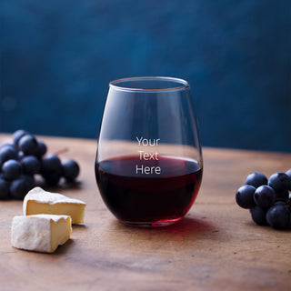 Stemless Red Wine glass sites on a table with grapes & cheese.  There's a space to add your own message.